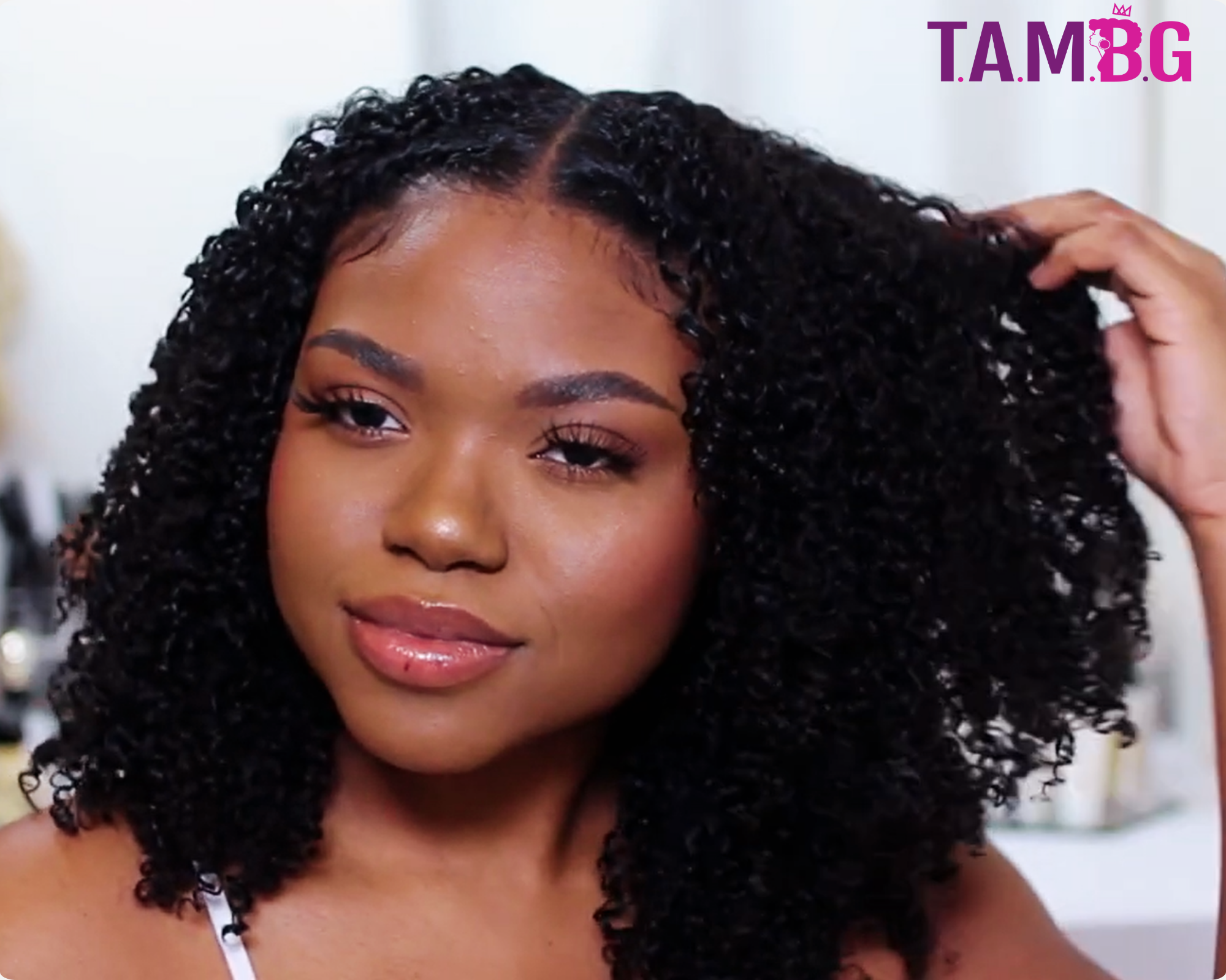 A woman holding her curly microlinks hair extension